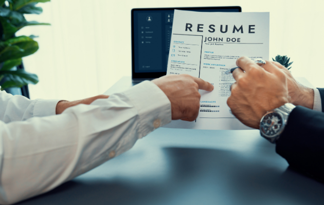 Job seeker tailoring a resume to a job description with ATS keywords highlighted on a computer screen
